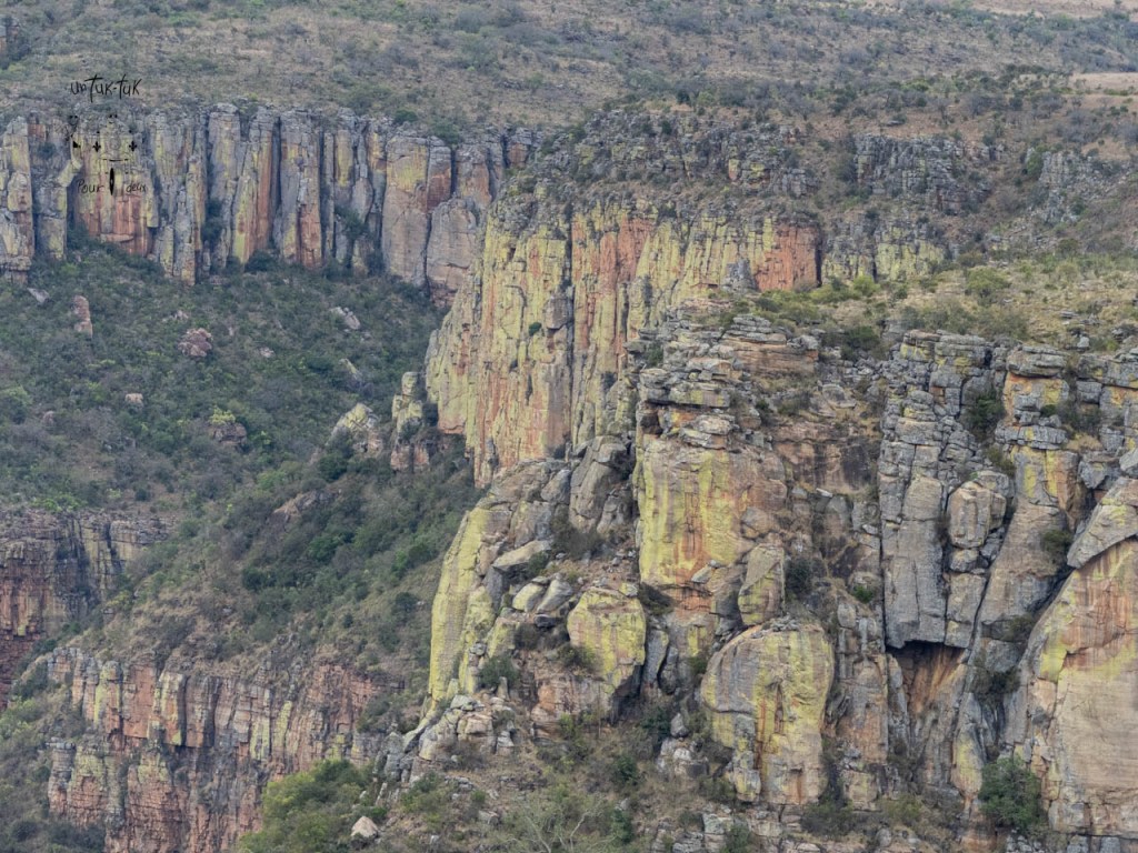 Vue panoramique des falaises colorées et de la végétation environnante.